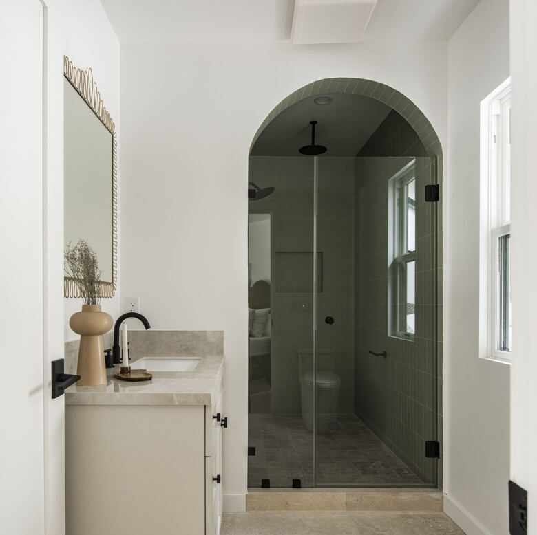 Bathroom with arched green tile shower